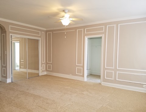 an empty living room with a ceiling fan
